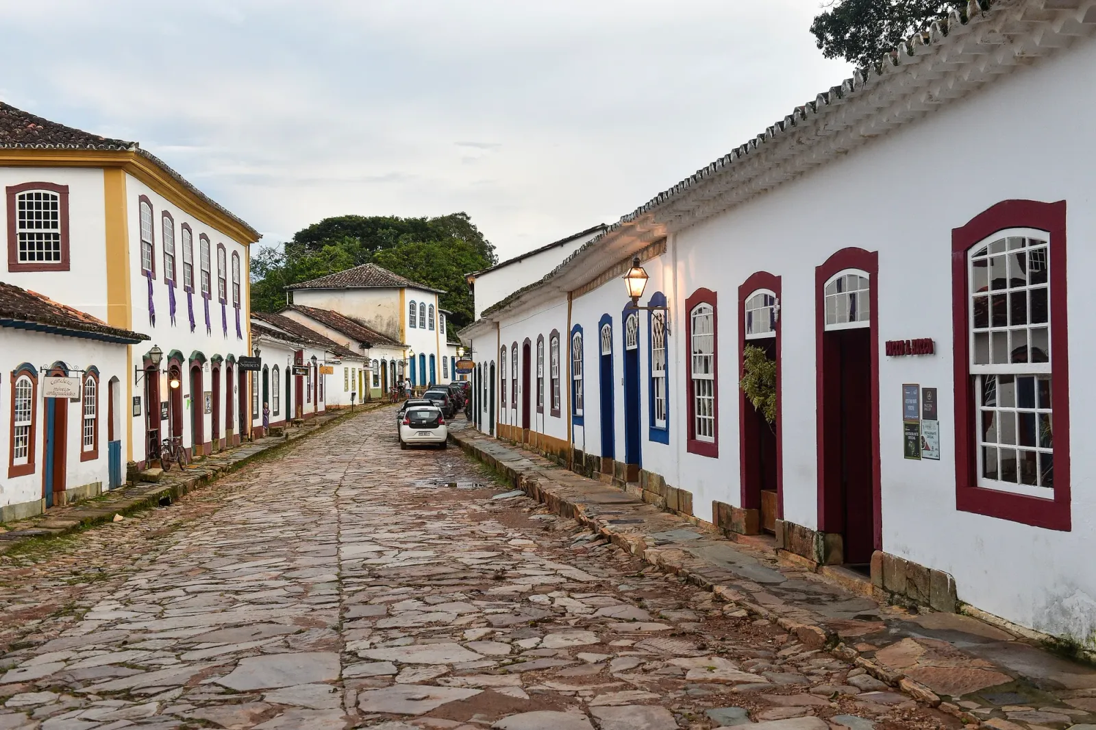 Rua de pedra do centro histórico de Tiradentes, com sobrados brancos de janelas coloridas