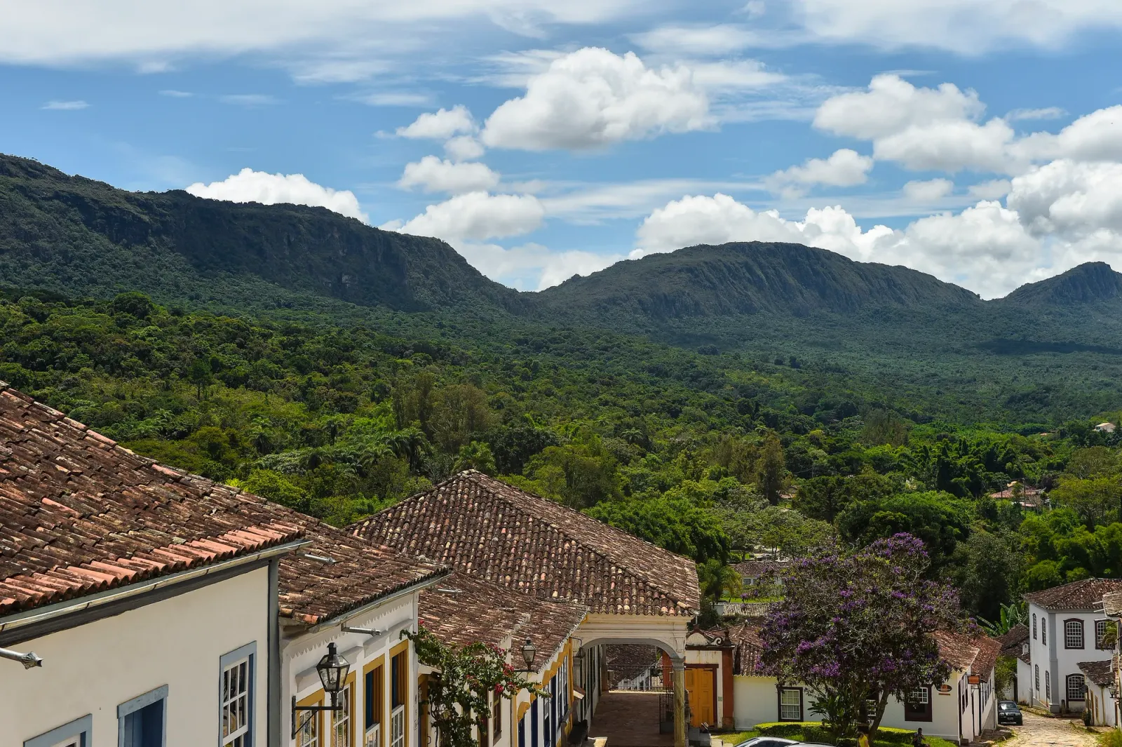 Telhados de Tiradentes e a mata da Serra de São José sob céu com nuvens